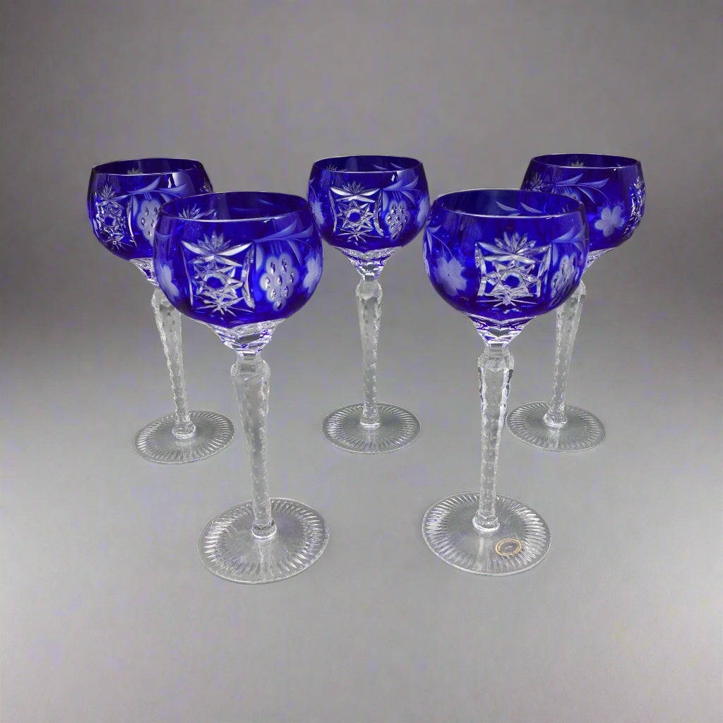 Set of six blue-cut-to-clear wine glasses on a gray background